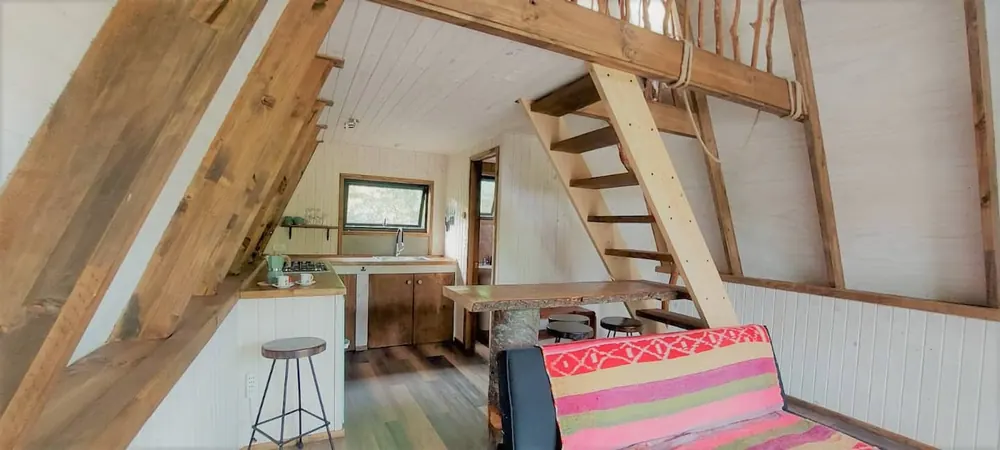 Cabin interior with wooden stairs up to the loft